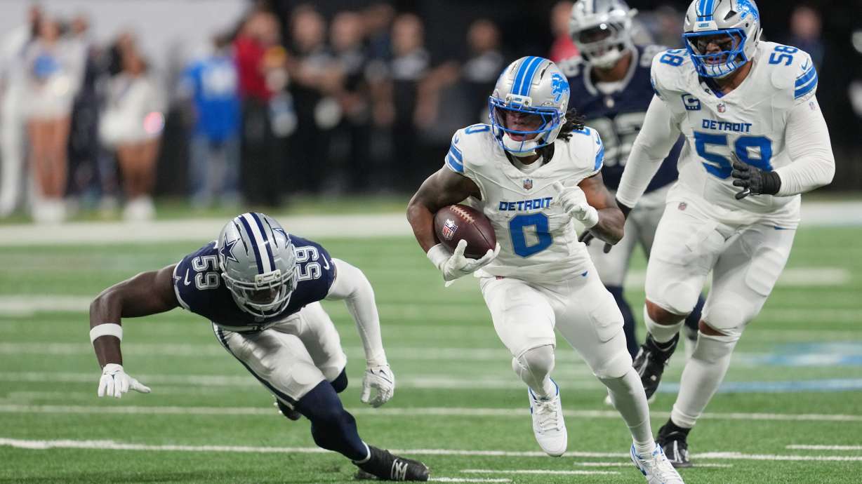 Detroit Lions running back Jahmyr Gibbs (0) runs the ball as Dallas Cowboys linebacker Jr. Kenneth Murray (59) tries to stop him during the first half of an NFL football game Thursday, Dec. 4, 2025, in Detroit.