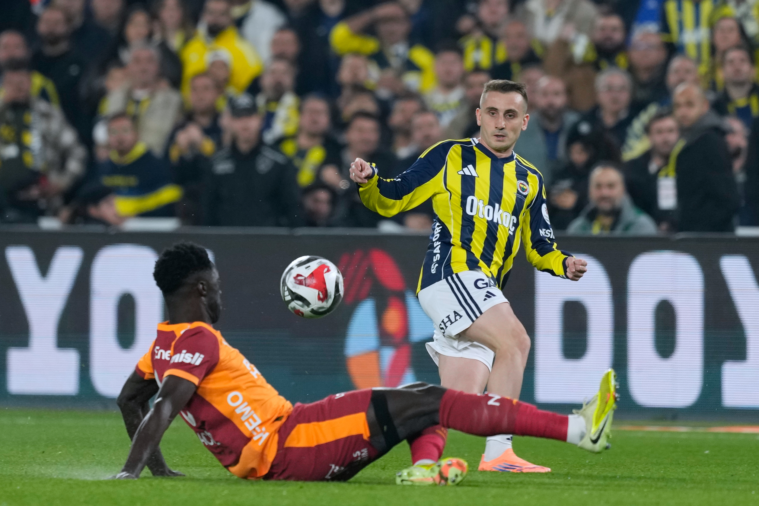 Fenerbahce's Kerem Akturkoglu, right, fights for the ball with Galatasaray's Davinson Sanchez during a Turkish Super Lig soccer match between Fenerbahce and Galatasaray, in Istanbul, Turkey, Monday, Dec. 1, 2025.