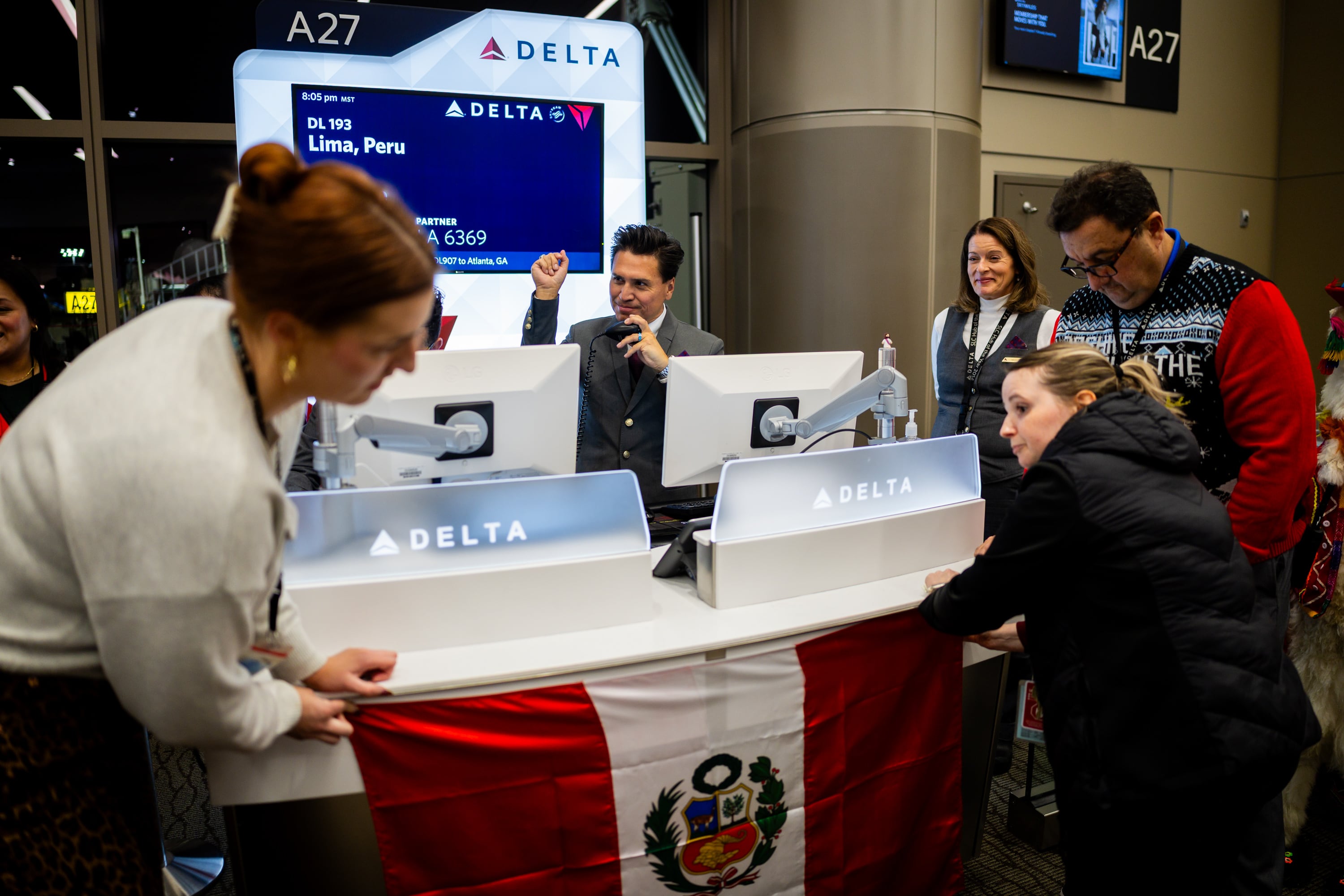Victor Avalos, center, works as customer service agent as people pin up the flag of Peru for Delta’s maiden flight from Salt Lake City to Lima, Peru, operating daily seasonal service using a Boeing 767-300ER until Jan. 25, 2026, at the Salt Lake City International Airport in Salt Lake City on Thursday. Legions of Utahns have connections to the South American nation.