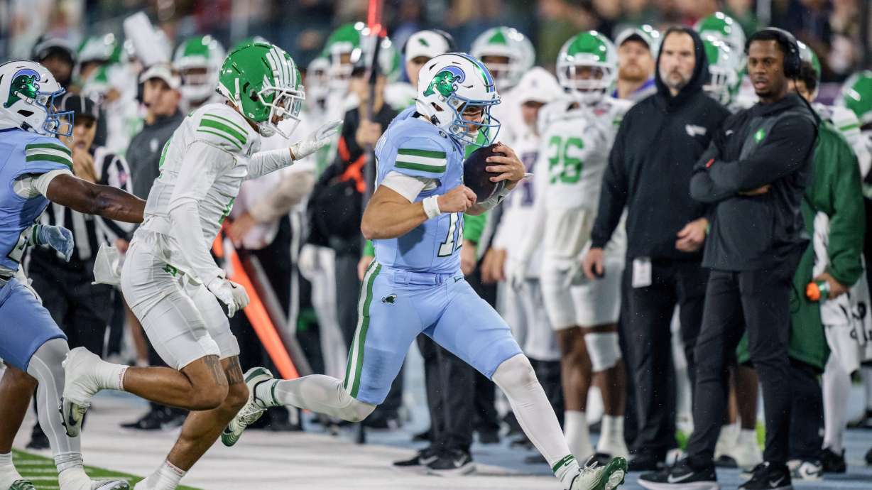 Tulane quarterback Jake Retzlaff, front right, runs against North Texas cornerback Da'Veawn Armstead, second from front right, during the first half of the American Conference championship NCAA college football game in New Orleans, Friday, Dec. 5, 2025.