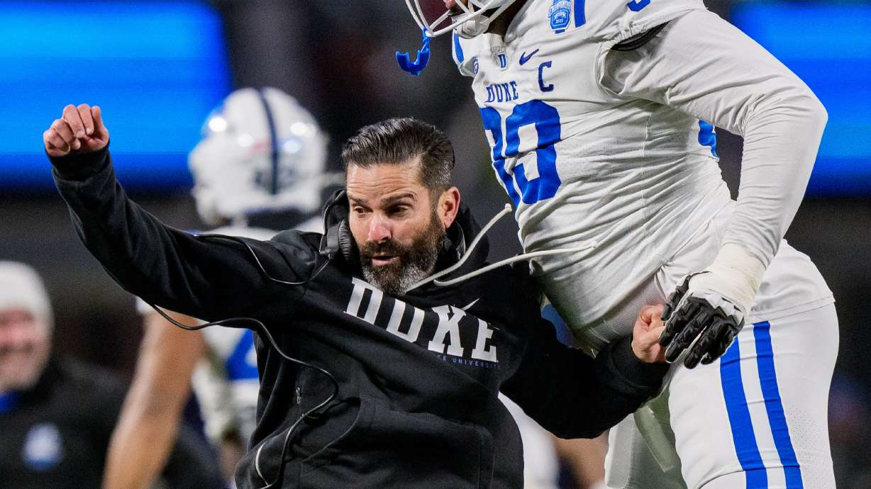 Duke head coach Manny Diaz, left, celebrates with defensive tackle Aaron Hall (99) after Virginia missed a field goal in the first half of the Atlantic Coast Conference championship NCAA college football game Saturday, Dec. 6, 2025, in Charlotte, N.C.