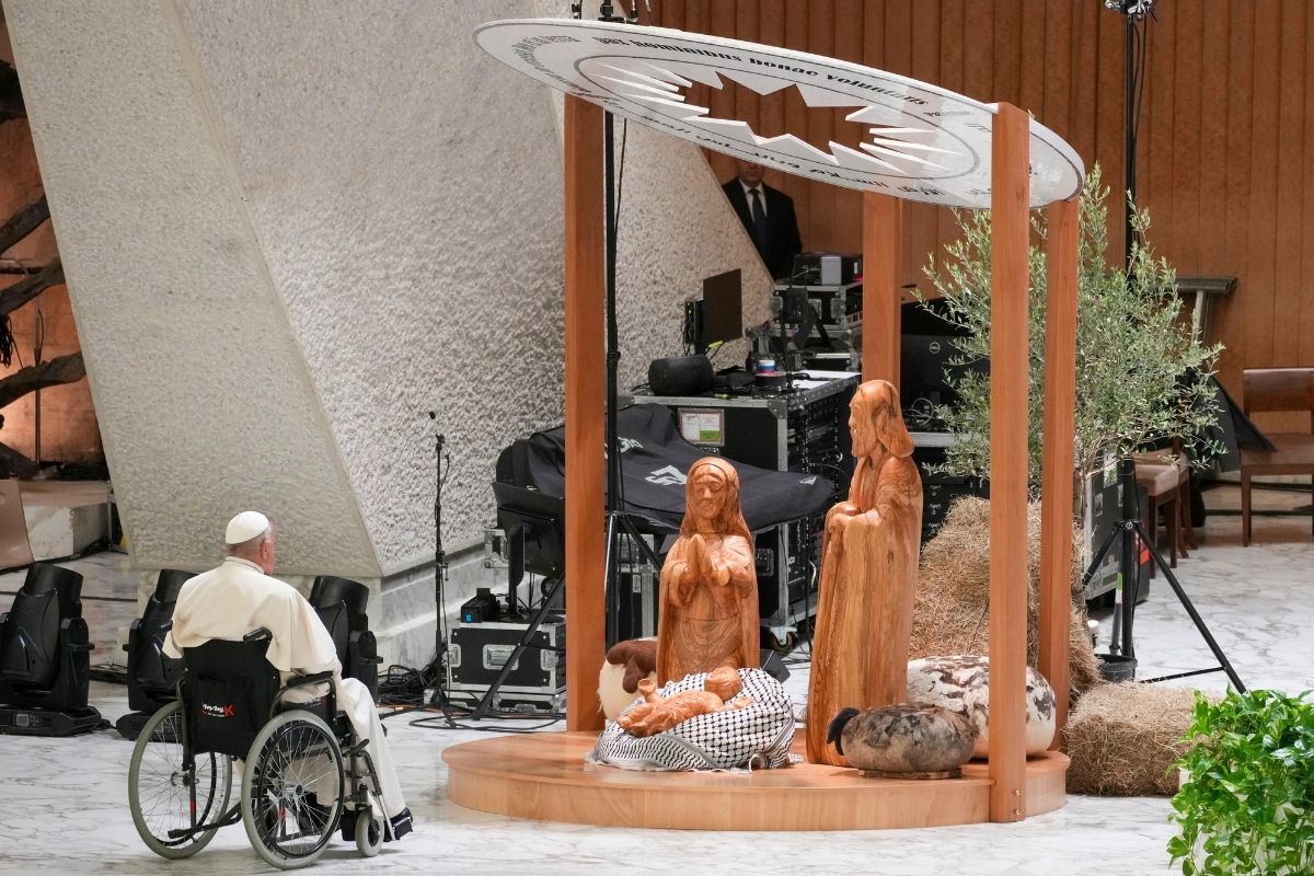 Pope Francis prays in front of a Nativity scene crafted in the West Bank city of Bethlehem, in the Paul VI hall at the Vatican, Dec. 7, 2024.