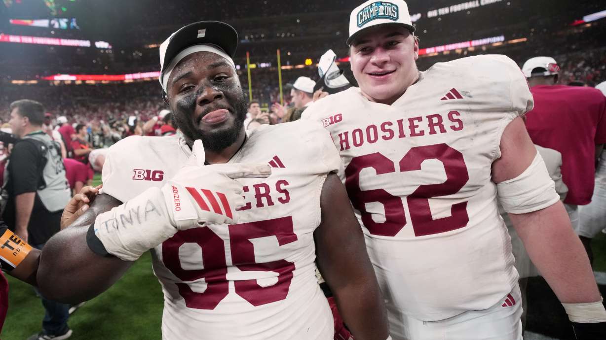 Indiana's Tyrique Tucker and Drew Evans celebrate after the Big Ten championship NCAA college football game against Ohio State in Indianapolis, Saturday, Dec. 6, 2025.