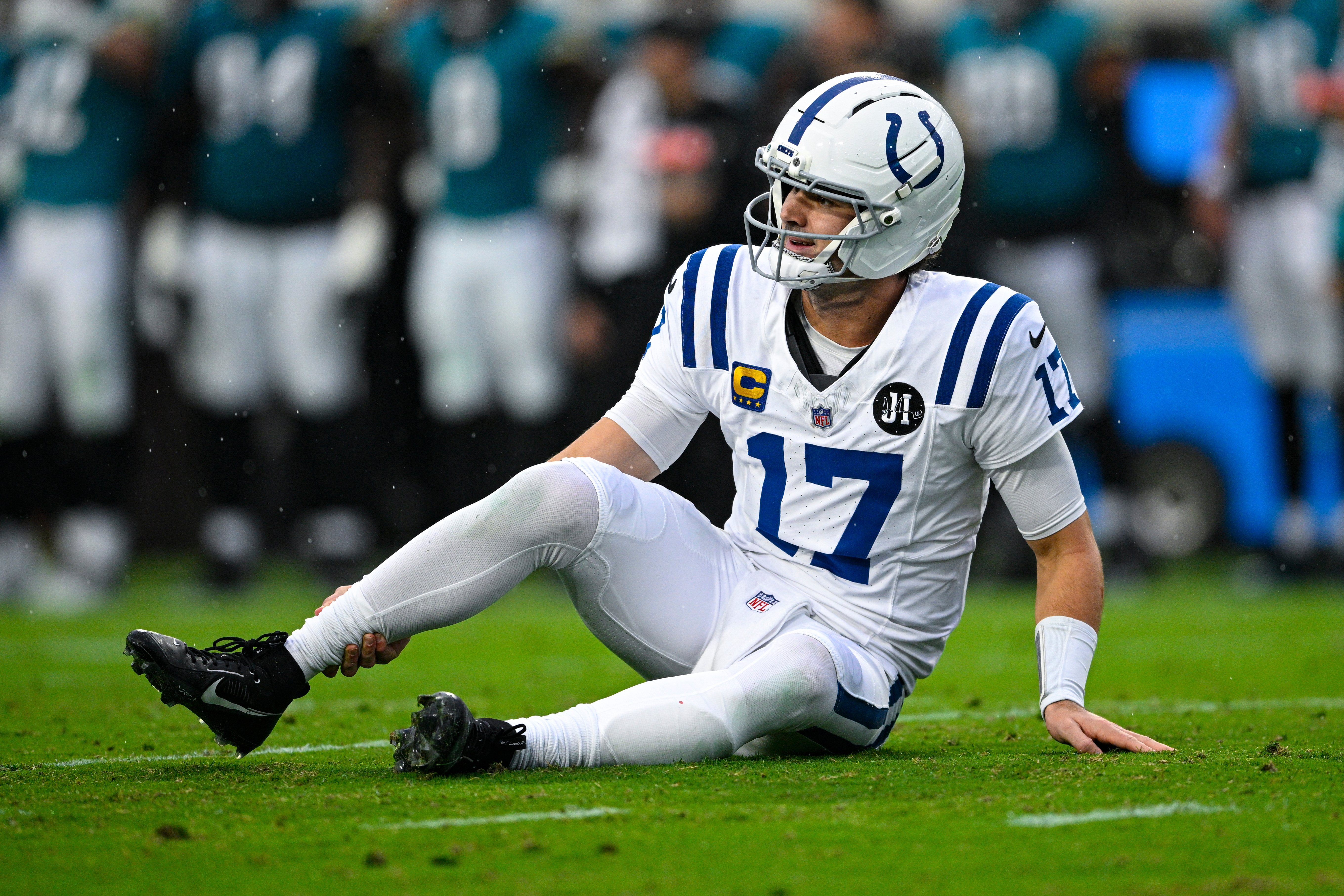 Indianapolis Colts quarterback Daniel Jones (17) grabs his leg after an injury during the first half of an NFL football game against the Jacksonville Jaguars, Sunday, Dec. 7, 2025, in Jacksonville, Fla.