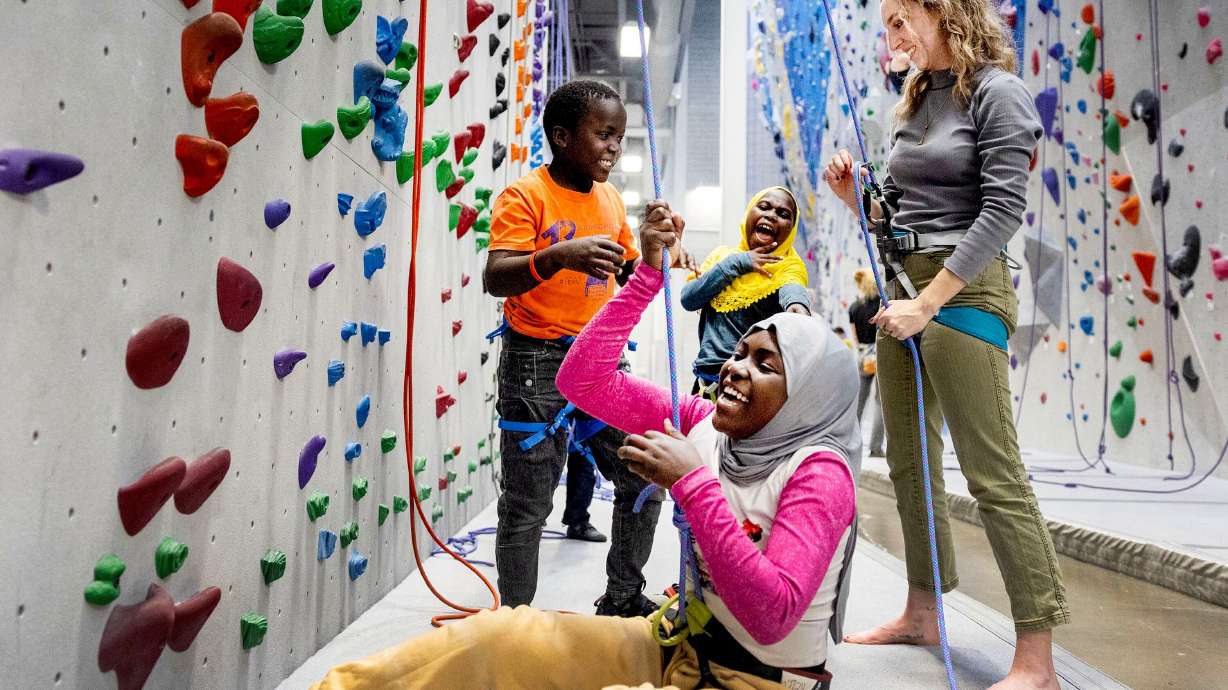 Hamida Zakariy, her brother Adam and sister Jamila laugh with Catholic Community Services volunteer Quinn Hennessy during an outing at Momentum Climbing Gym in Millcreek on Nov. 12. Hennessy has been a volunteer with the CCS refugee mentor program for two years. The Zakariy family, from Sudan, is the second family she has worked with since joining the program.