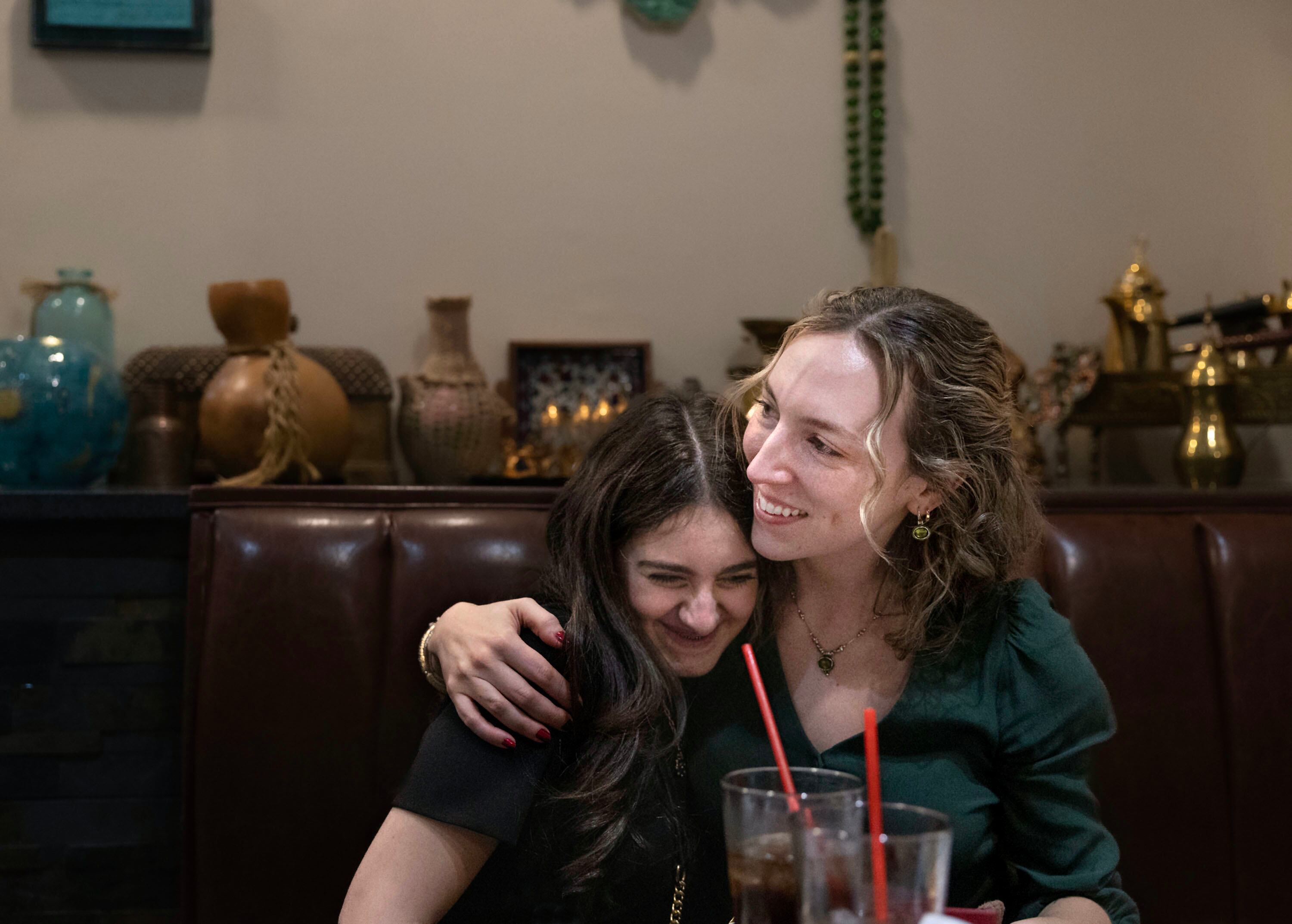 Selena Zarour, 15, is hugged by Quinn Hennessy during Hennessy’s birthday dinner at Shanasheel Grill in Salt Lake City on Nov. 17. Hennessy, a refugee mentor with Catholic Community Services, spent a year with the Zarour family as they arrived in Utah from Syria. Hennessy’s time volunteering with the family ended a year ago, but they continue to stay in touch.