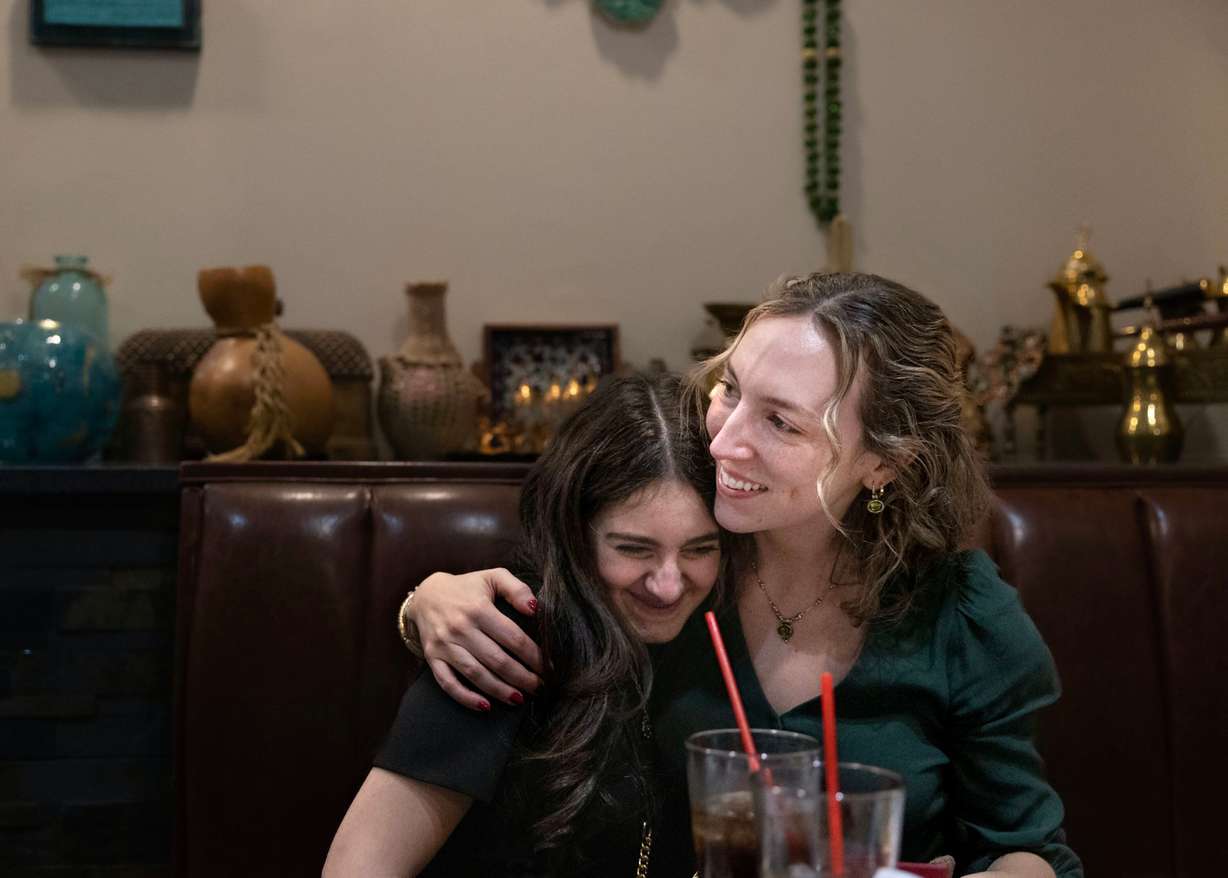 Selena Zarour, 15, is hugged by Quinn Hennessy during Hennessy’s birthday dinner at Shanasheel Grill in Salt Lake City on Nov. 17. Hennessy, a refugee mentor with Catholic Community Services, spent a year with the Zarour family as they arrived in Utah from Syria. Hennessy’s time volunteering with the family ended a year ago, but they continue to stay in touch.