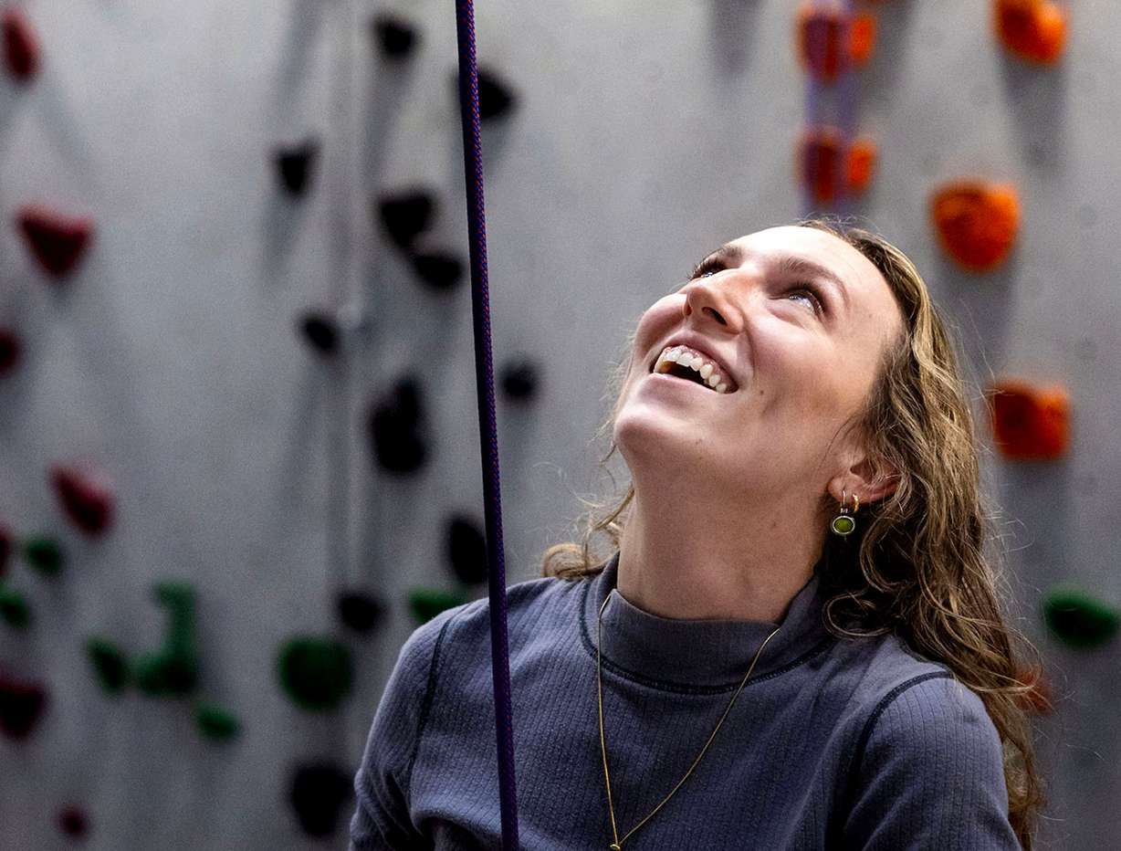 Catholic Community Services volunteer Quinn Hennessy smiles as one of the Zakariy children climbs at Momentum Climbing Gym in Millcreek on Nov. 12. Hennessy has been a volunteer with the CCS refugee mentor program for two years. The Zakariy family, from Sudan, is the second family she has worked with since joining the program.
