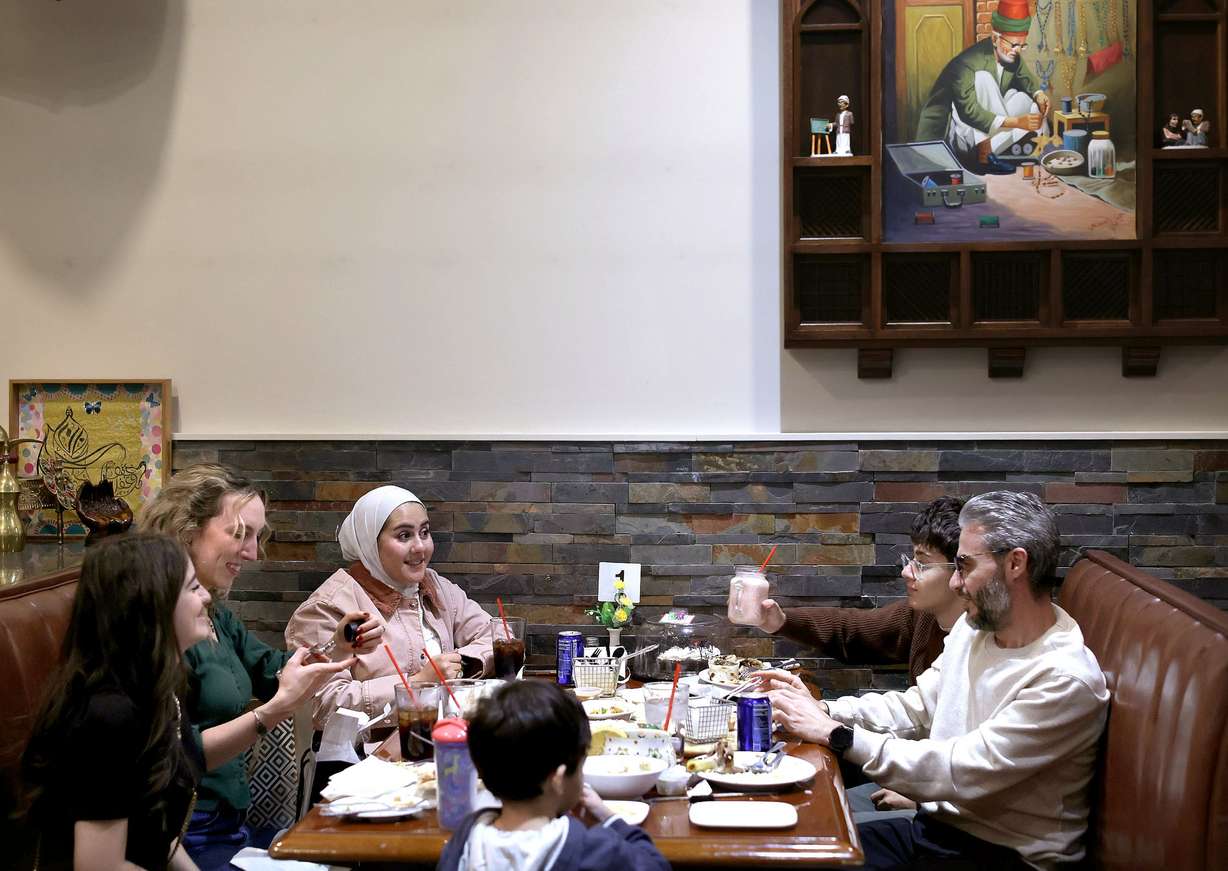 The Zarour family — Selena, left, her mother Shahinaz Alhasaan, her brother Abdul, father Ahmad and little brother, Ghaith — celebrate Quinn Hennessy’s birthday at Shanasheel Grill in Salt Lake City on Nov. 17. Hennessy, a refugee mentor with Catholic Community Services, spent a year with the Zarour family when they arrived in Salt Lake City from Syria. Hennessy’s time volunteering with the family ended a year ago, but they continue to stay in touch.