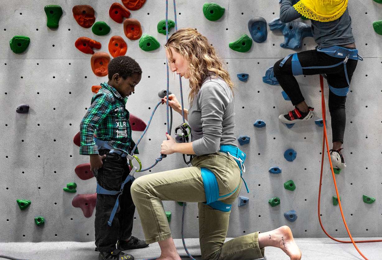 Catholic Community Services volunteer Quinn Hennessy sets up a belay system for Amidu Zakariy during an outing at Momentum Climbing Gym in Millcreek on Nov. 12. Hennessy has been a volunteer with the refugee mentor program for two years. The Zakariy family, from Sudan, is the second family she has worked with since joining the program.