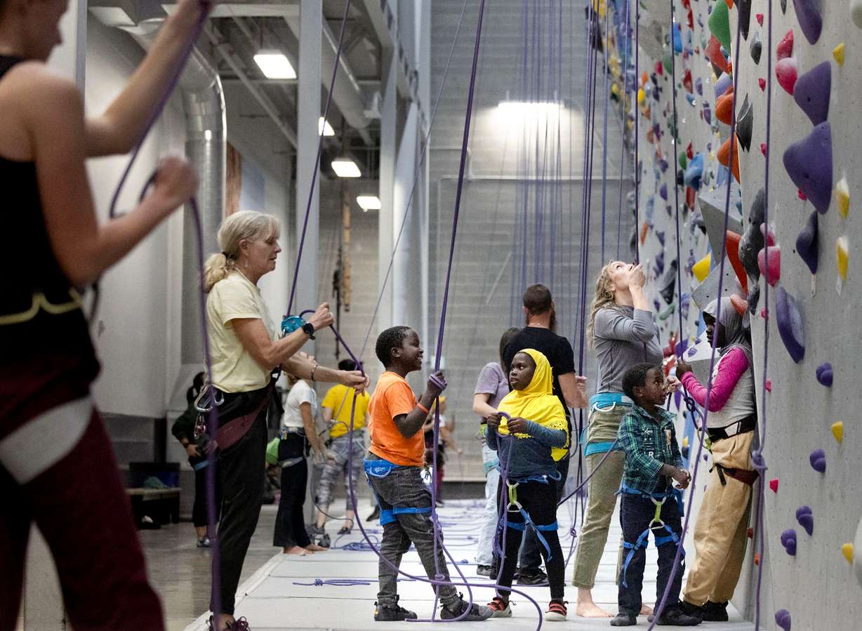 Catholic Community Services volunteer Quinn Hennessy sets up a belay while climbing with Adam, Jamila, Amidu and Hamida Zakariy at Momentum Climbing Gym in Millcreek on Nov. 12. Hennessy has been a volunteer with the CCS refugee mentor program for two years. The Zakariy family, from Sudan, is the second family she has worked with since joining the program.