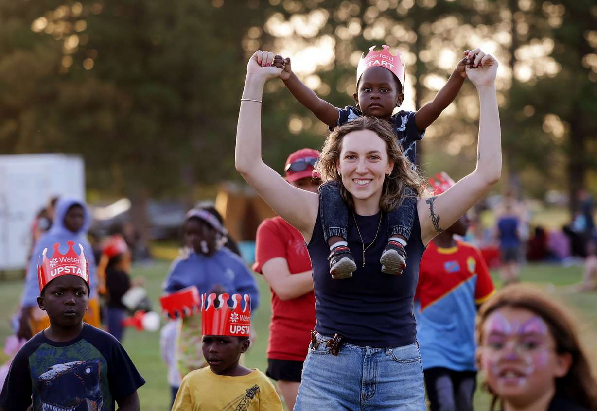 Quinn Hennessy carries Fahimu Zakaria on her shoulders at the 21st annual Utah Refugee Day celebration at the Big Cottonwood Regional Park in Millcreek on June 20.