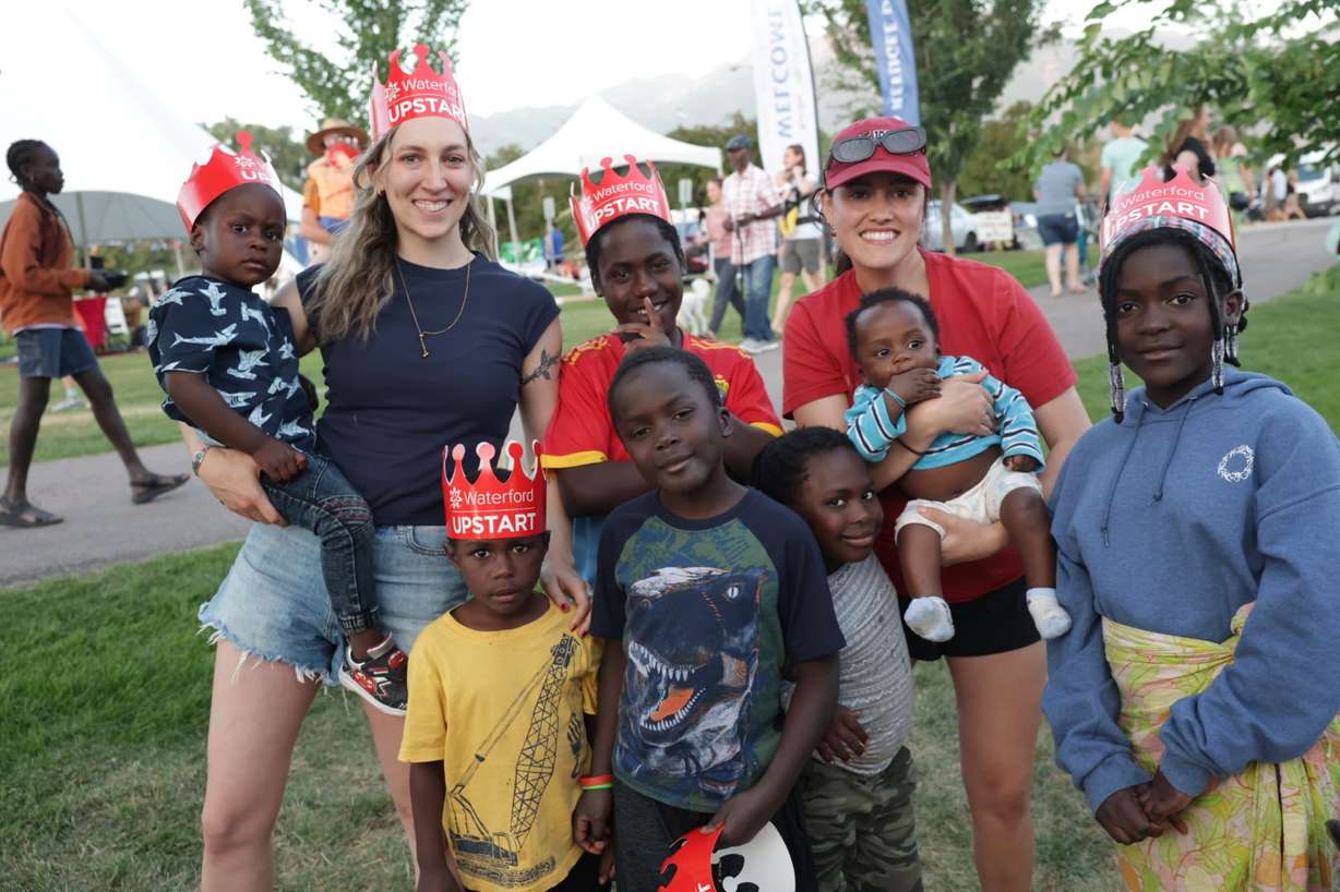 Quinn Hennessy, left, and her sister, Kelley Hennessy, pose for a photo with seven of the eight Zakaria children at the 21st annual Utah Refugee Day celebration at the Big Cottonwood Regional Park in Millcreek on June 20.