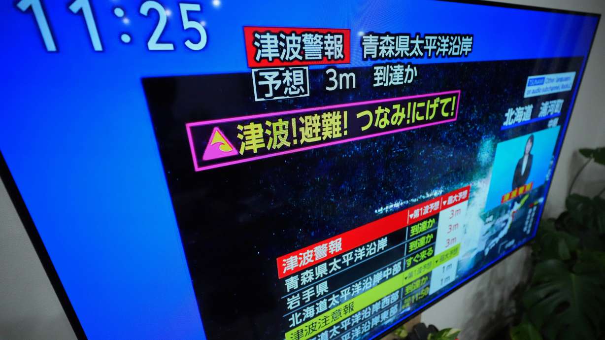 A tsunami warning is displayed on a television in Yokohama, near Tokyo, Monday, after a strong earthquake hits off Japanese northern coast, tsunami alert issued.