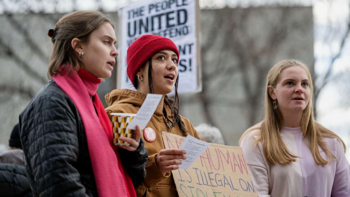Riley Barrett, Samantha Reagan, Mikayla Torrey and others demonstrated at the U.S. Citizenship and Immigration Services office in Salt Lake City on Monday. They were there amid reports immigrants entering the office would face detention.