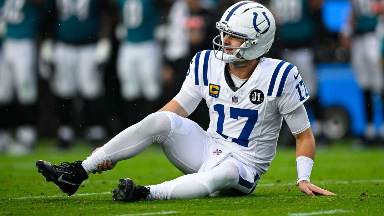 Indianapolis Colts quarterback Daniel Jones (17) grabs his leg after an injury during the first half of an NFL football game against the Jacksonville Jaguars, Sunday, Dec. 7, 2025, in Jacksonville, Fla.