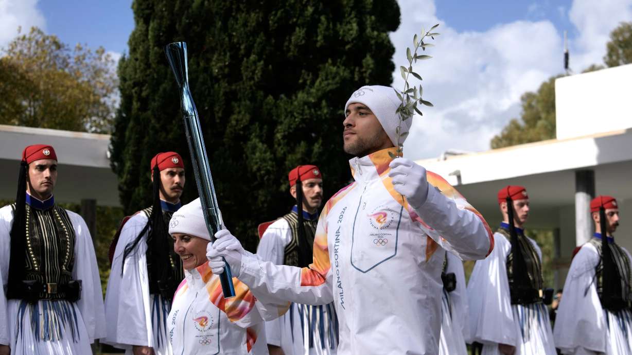 Greek rower Petros Gaidatzis and former Italian cross-country skier Stefania Belmondo start the torch relay after the ceremony of the flame lighting for the Milan Cortina 2026 Winter Olympics, at the archaeological museum of Olympia, Greece, Nov. 26.