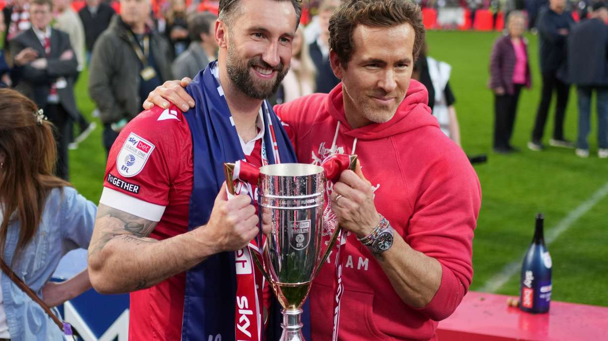FILE - Wrexham co-owner Ryan Reynolds, right, and Wrexham's Ollie Palmer pose with trophy at the end of the English League One soccer match between Wrexham and Charlton Athletic at the Racecourse ground in Wrexham, Wales, April 26, 2025.