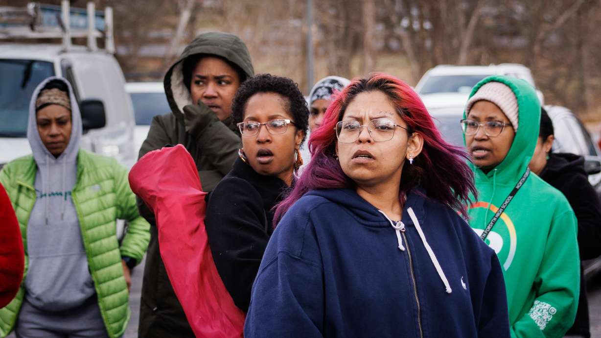 Family members and friends of North Forsyth High School students wait in a parking lot across the street from the school after a fatal stabbing, Tuesday, in Winston-Salem, N.C. One student died and another was injured, authorities said.