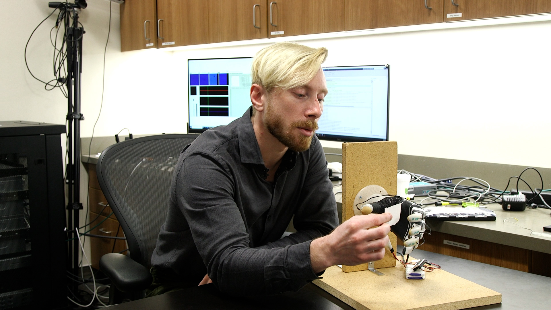 Post-doctoral researcher Marshall Trout demonstrates the use of a new bionic hand equipped with artificial intelligence, Tuesday. Trout developed the technology with the help of University of Utah professor Jacob George.