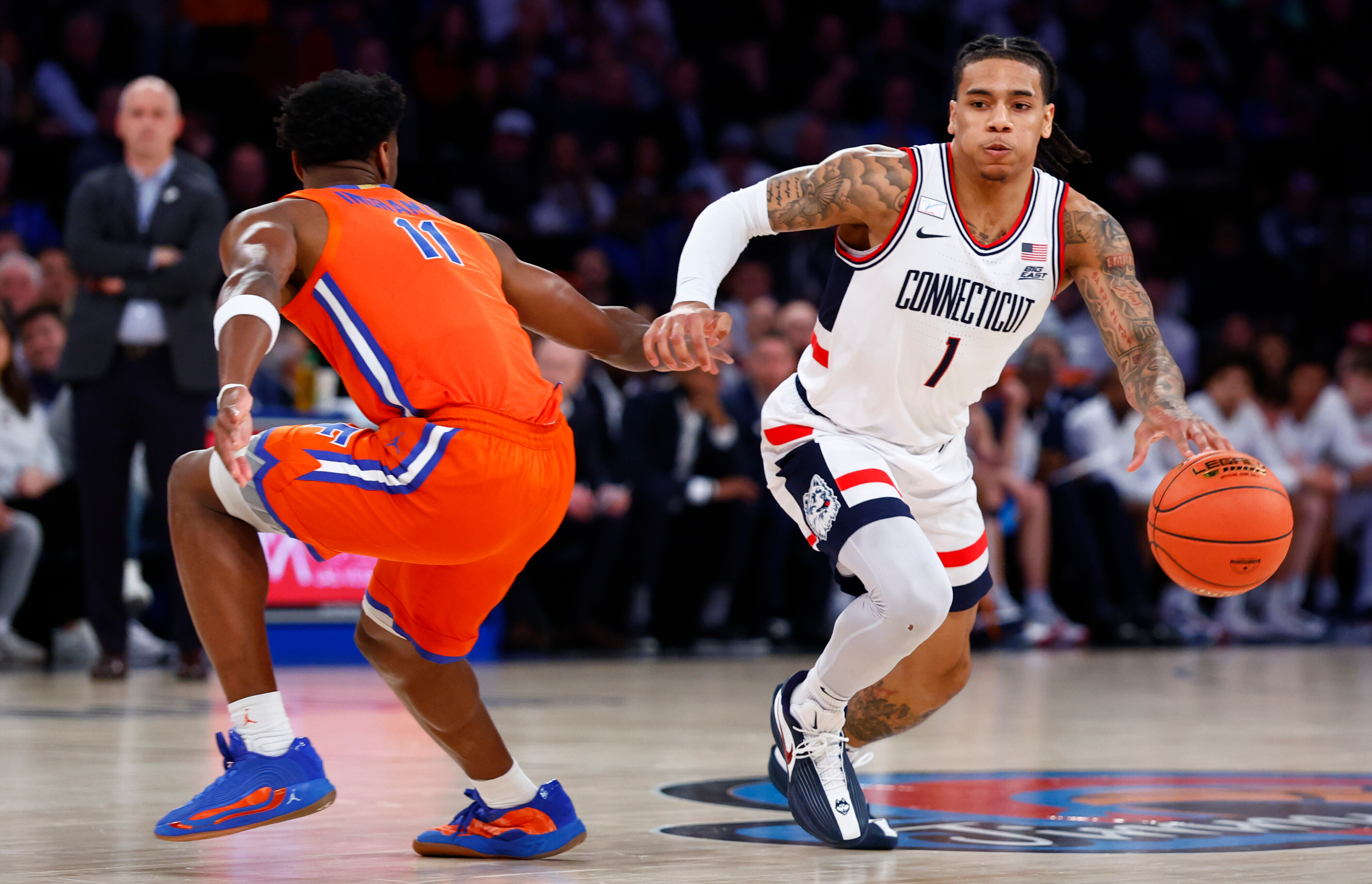 UConn guard Solo Ball (1) drives to the basket against Florida guard CJ Ingram II (11) during the first half of an NCAA basketball game, Tuesday, Dec. 9, 2025, in New York. 