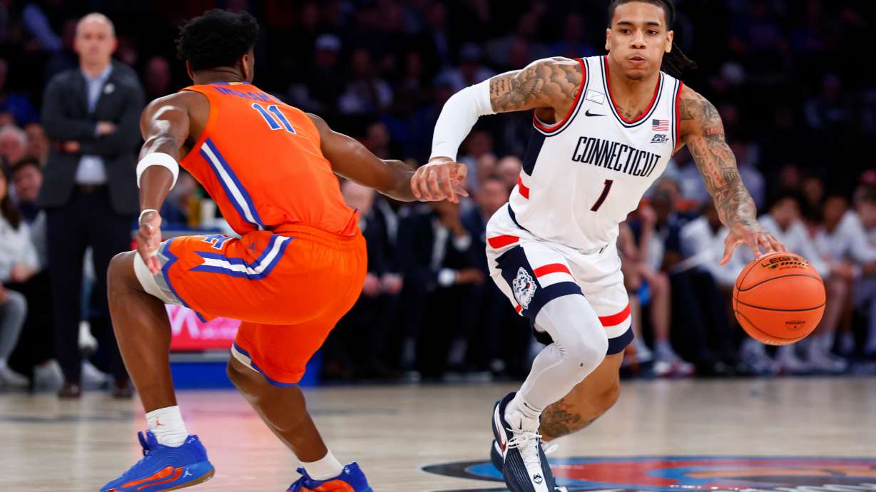 UConn guard Solo Ball (1) drives to the basket against Florida guard CJ Ingram II (11) during the first half of an NCAA basketball game, Tuesday, Dec. 9, 2025, in New York.