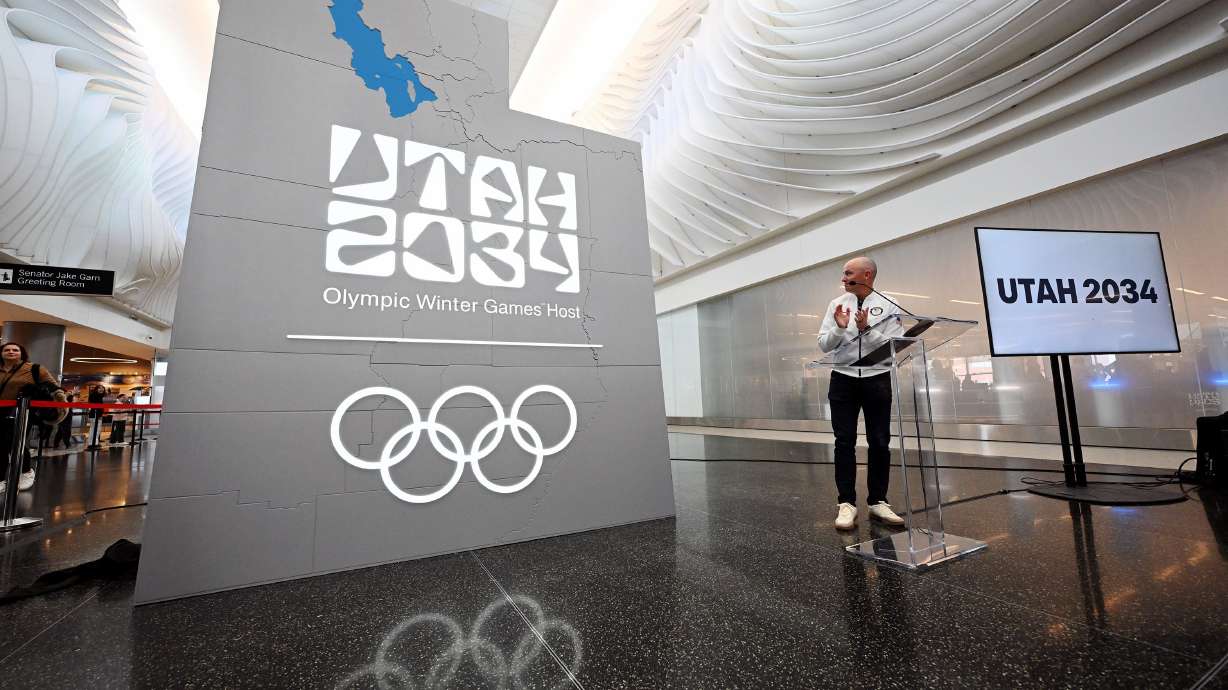 Gov. Spencer Cox looks at the new Utah 2034 sign, unveiled in the Canyon section of the Salt Lake City International Airport, in a ceremony to celebrate 3,000 days until the 2034 Winter Olympics on Nov. 24. IOC President Kirsty Coventry supported the name change, noting recent rule changes to add regions, cities, or countries to host city names.