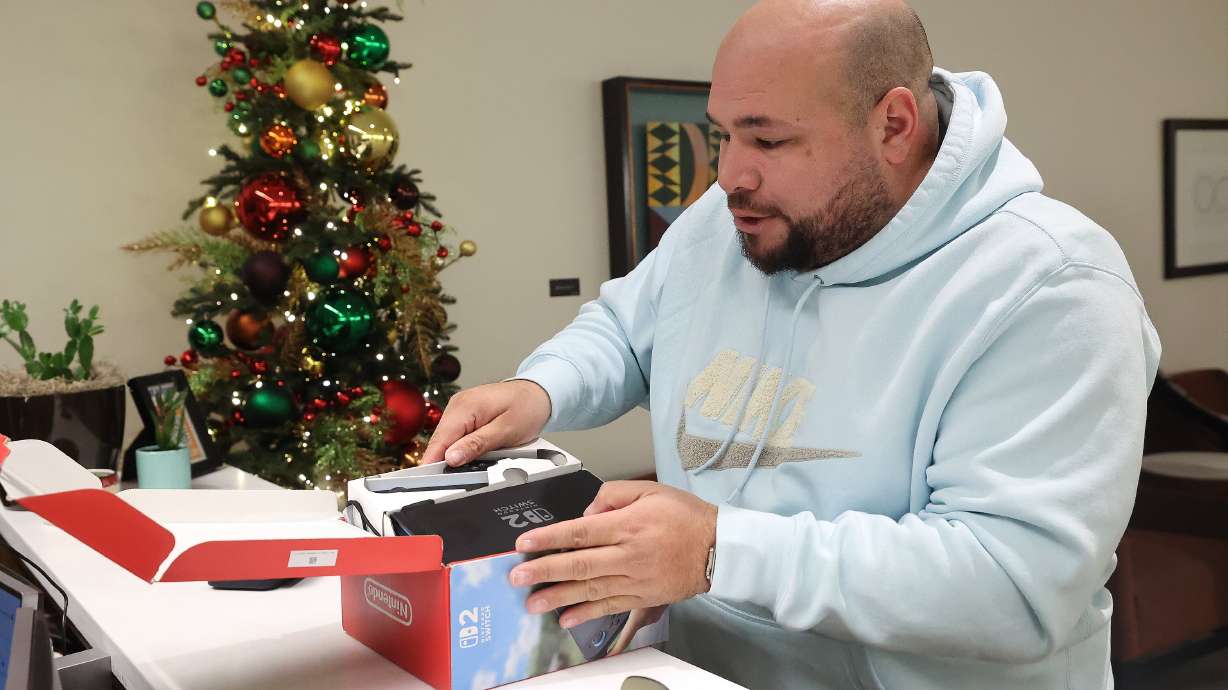 Gustavo Lugo gets reunited with a Nintendo Switch he got in Japan at the lost and found at the Salt Lake City International Airport in Salt Lake City on Dec. 4.