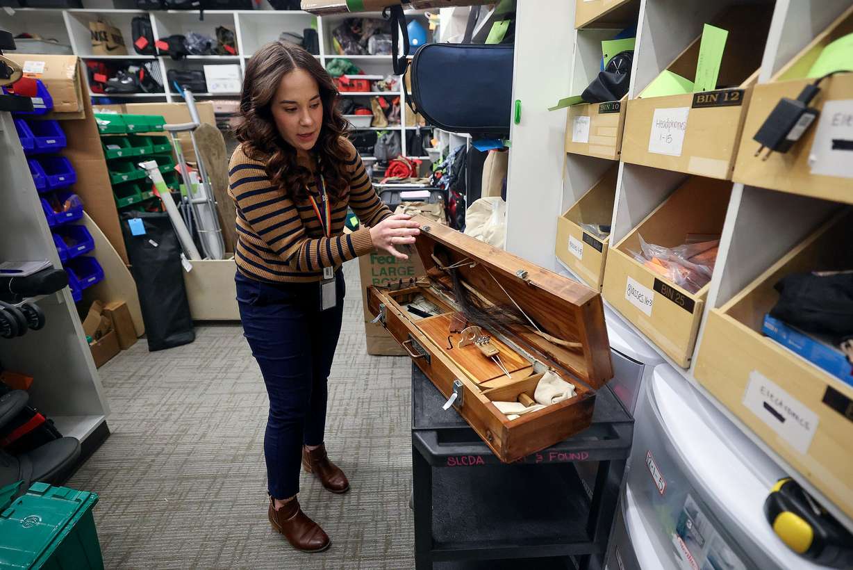 Melissa Royle, Salt Lake City International Airport customer service supervisor, shows one of many instruments that come through the lost and found at the Salt Lake City International Airport in Salt Lake City on Dec. 4.