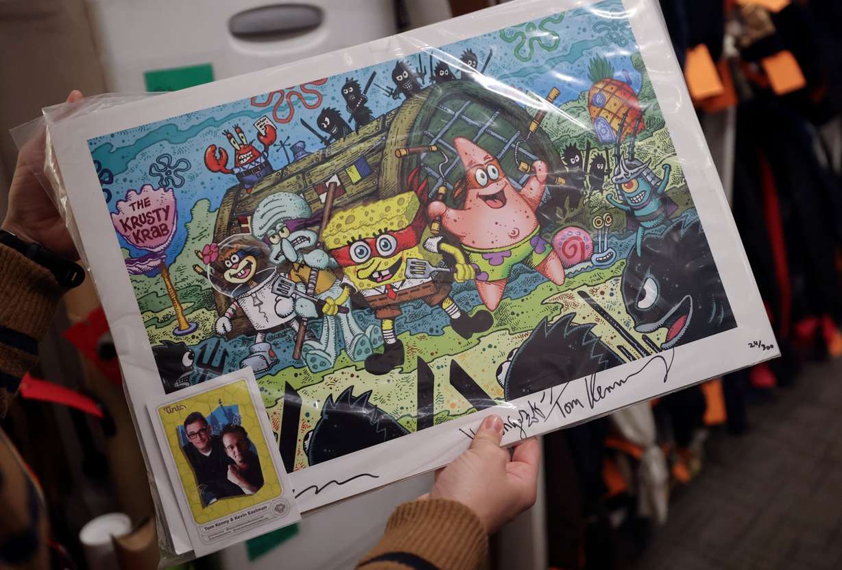 Melissa Royle, Salt Lake City International Airport customer service supervisor, shows signed prints at the lost and found at the Salt Lake City International Airport in Salt Lake City on Dec. 4.