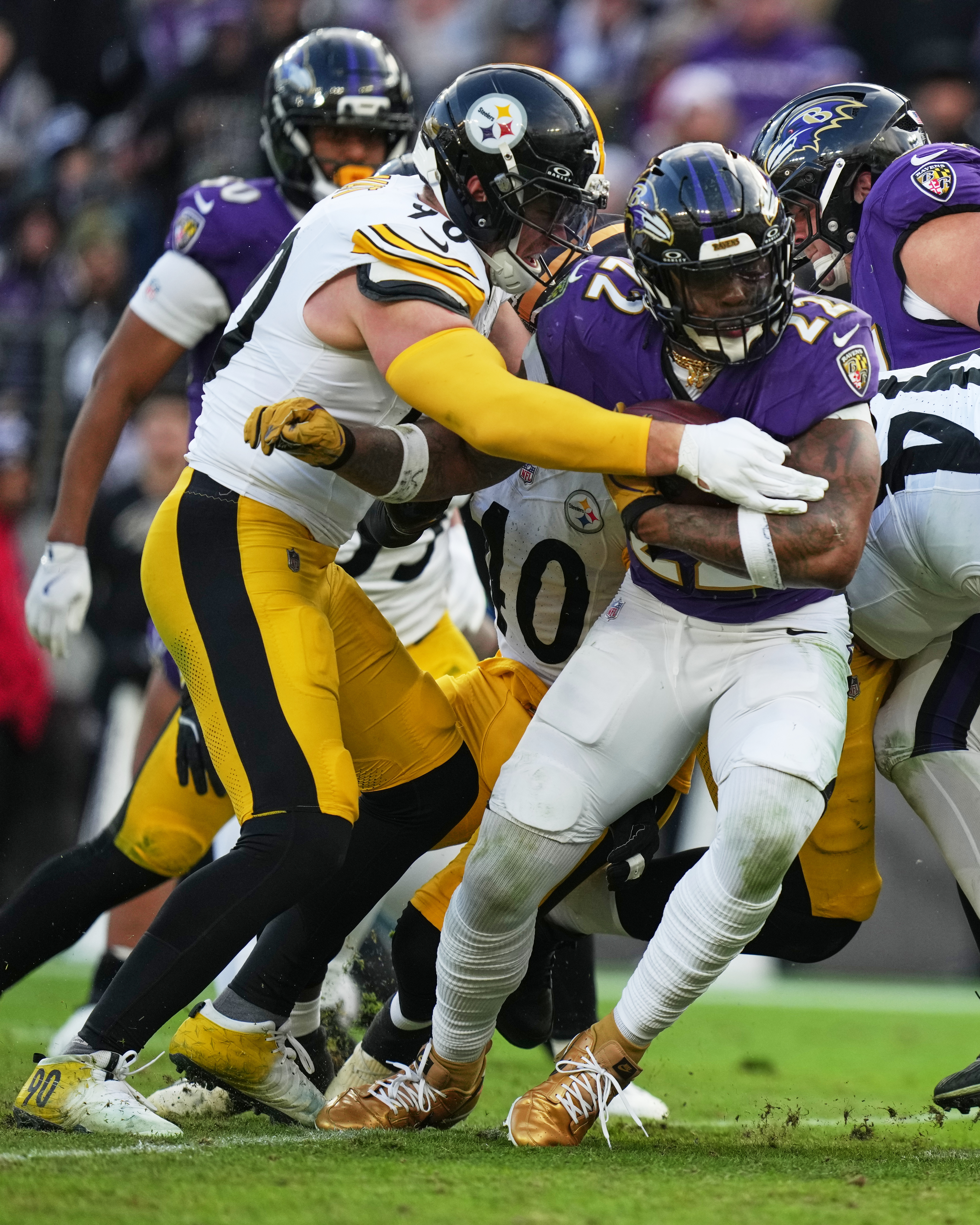 Baltimore Ravens running back Derrick Henry (22) is tackled by Pittsburgh Steelers linebacker T.J. Watt (90) during the second half of an NFL football game, Sunday, Dec. 7, 2025, in Baltimore.