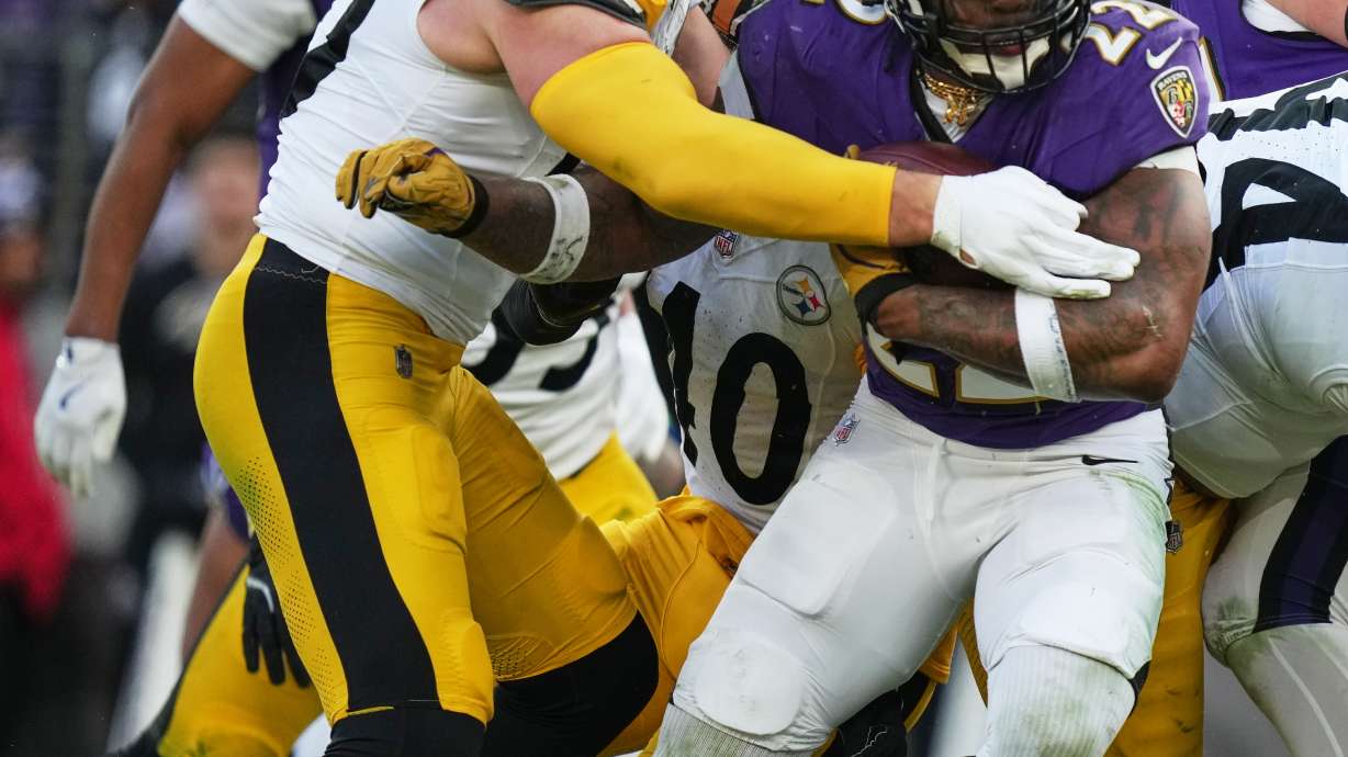 Baltimore Ravens running back Derrick Henry (22) is tackled by Pittsburgh Steelers linebacker T.J. Watt (90) during the second half of an NFL football game, Sunday, Dec. 7, 2025, in Baltimore.