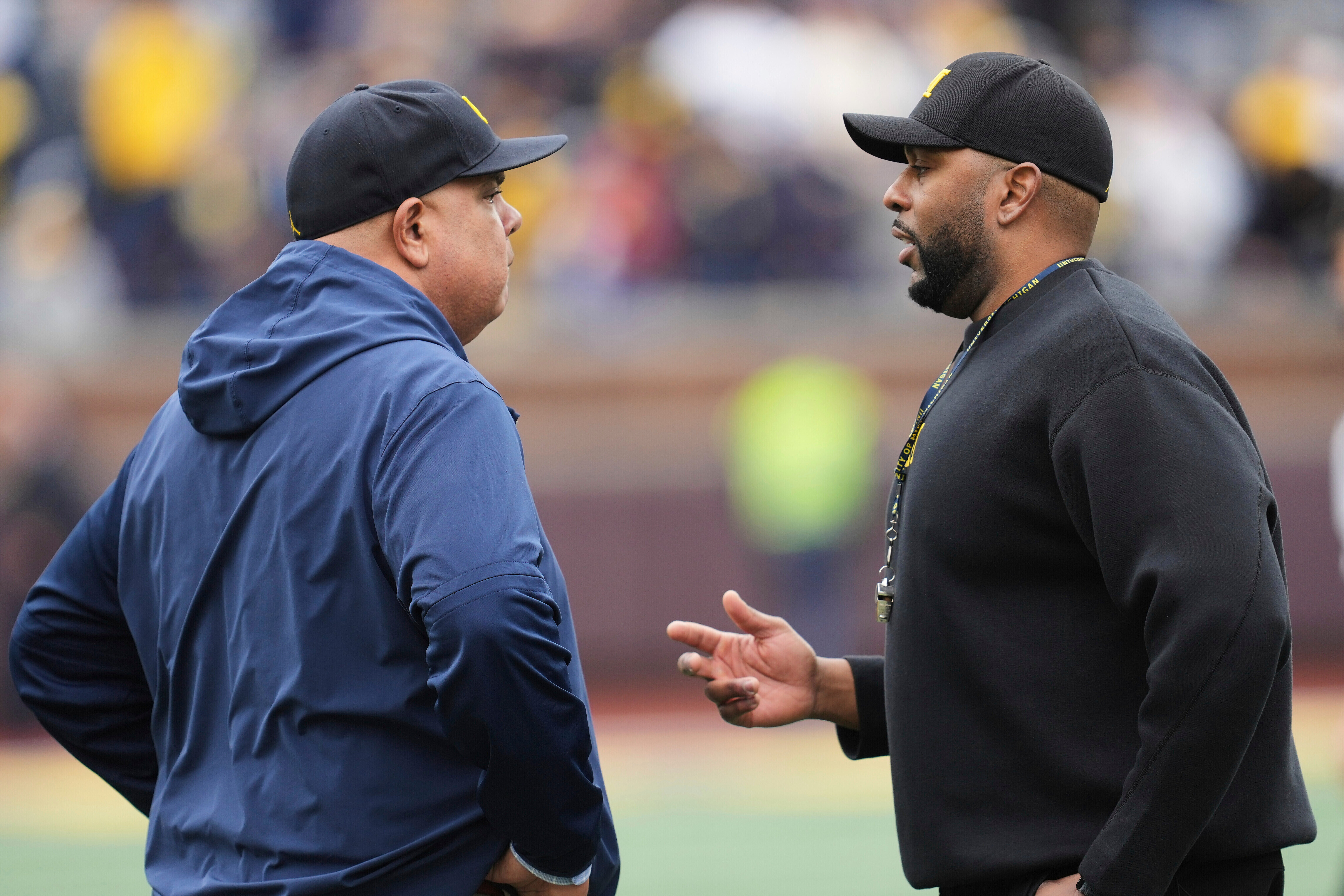 FILE - Michigan athletic director Warde Manuel, left, talks with head coach Sherrone Moore, right, before an NCAA college football spring game in Ann Arbor, Mich., April 19, 2025. 