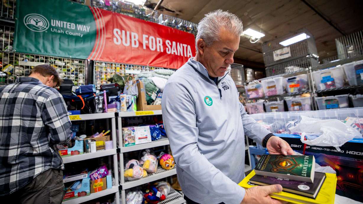 Volunteer Craig Freeze sorts books into a Sub for Santa package at United Way Utah County in Provo on Thursday.