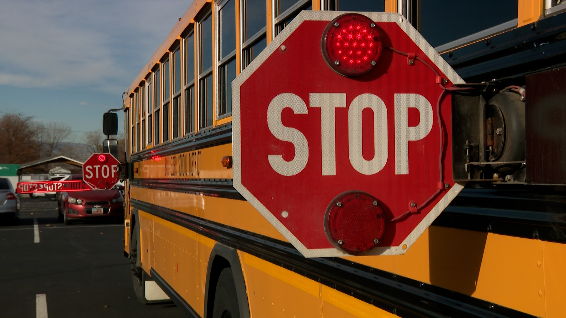 A stopped school bus with signs deployed in Willard, Box Elder County, Thursday. Officials are reminding drivers of the penalties for passing stopped buses.