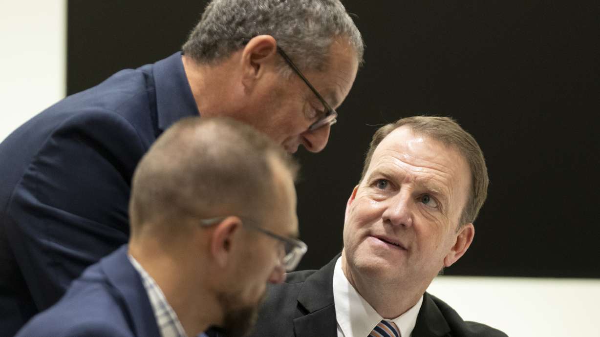Defense attorney Richard Novak, top, speaks with prosecutor Christopher Ballard on Dec. 11, 2025. If Tyler Robinson agrees that thousands witnessed Charlie Kirk's killing and a prosecutor's child isn't a material witness, the state won't introduce video of the killing at the next hearing.