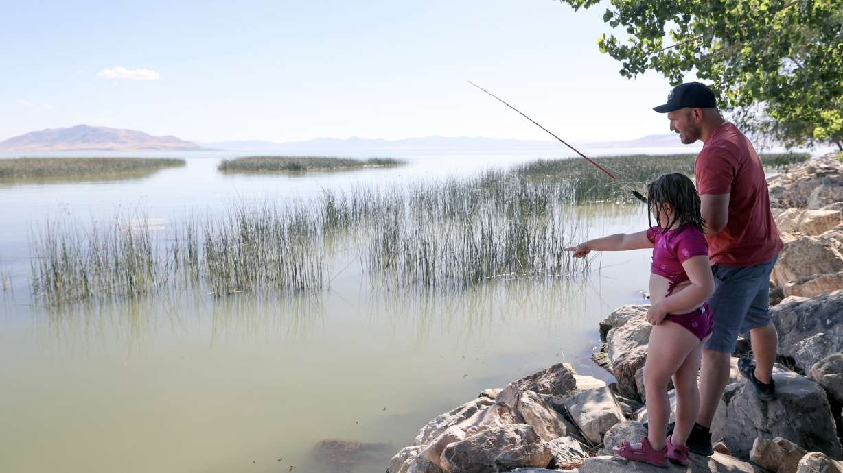 Stuart Webb fishes with his daughter Sailor Webb at Utah Lake State Park in Provo on July 28. Utah stocked bodies of water with more than 11.6 million fish over the past year, Utah wildlife officials said on Tuesday.