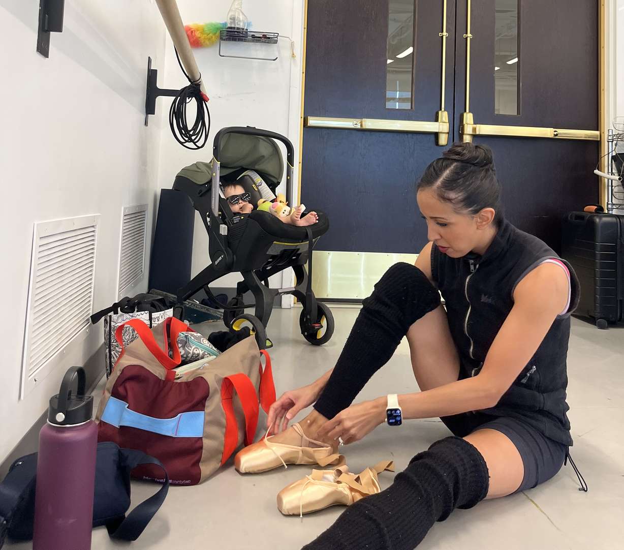 Ballet West principal artist Jenna Rae Herrera gets ready for dance class with her Theo in the dance studio.