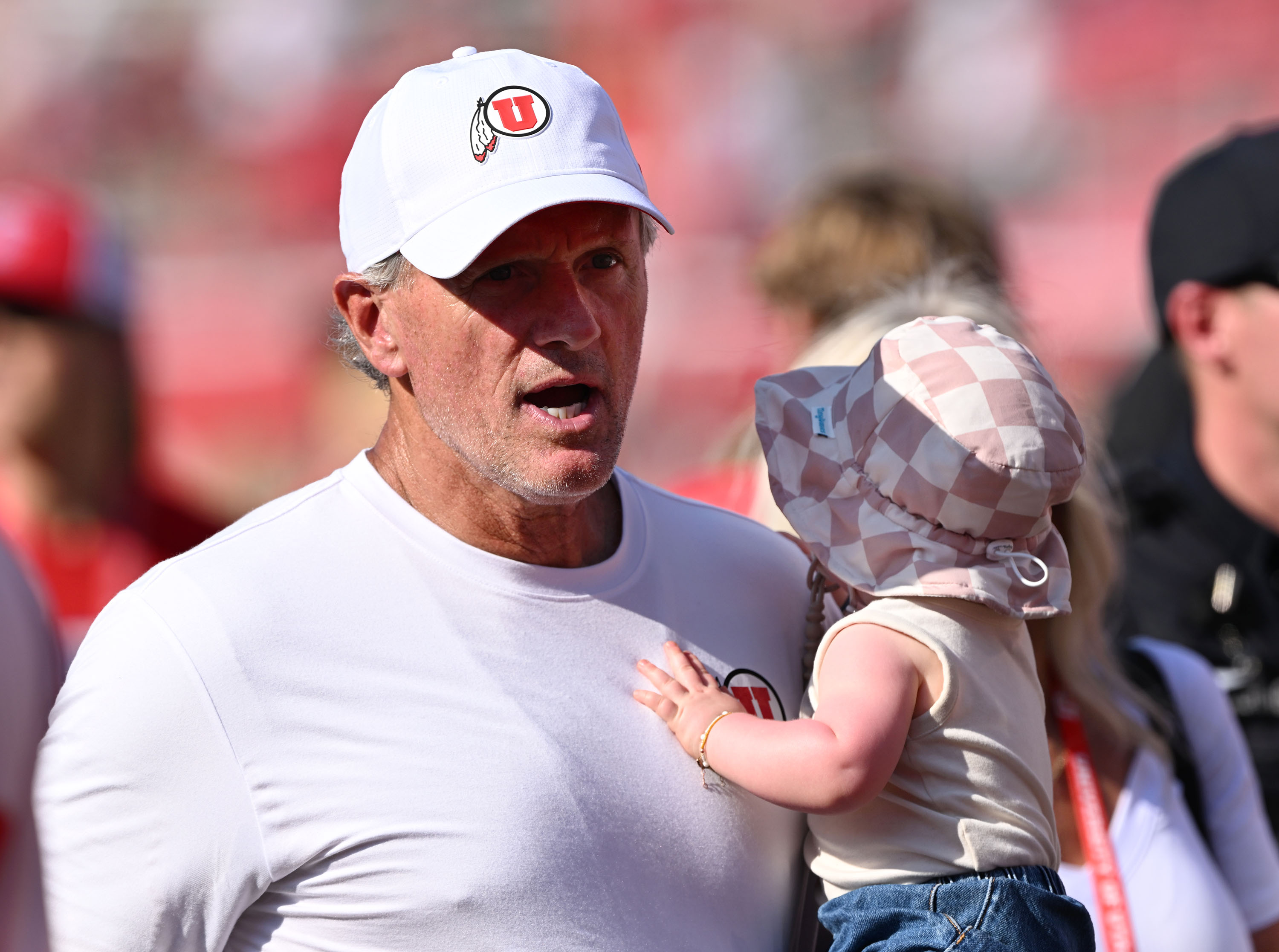 Utah Utes head coach Kyle Whittingham carries his granddaughter as he leaves the field after Utah defeated  Baylor at Rice-Eccles Stadium in Salt Lake City on Saturday, Sept. 7, 2024. Utah won 23-12.