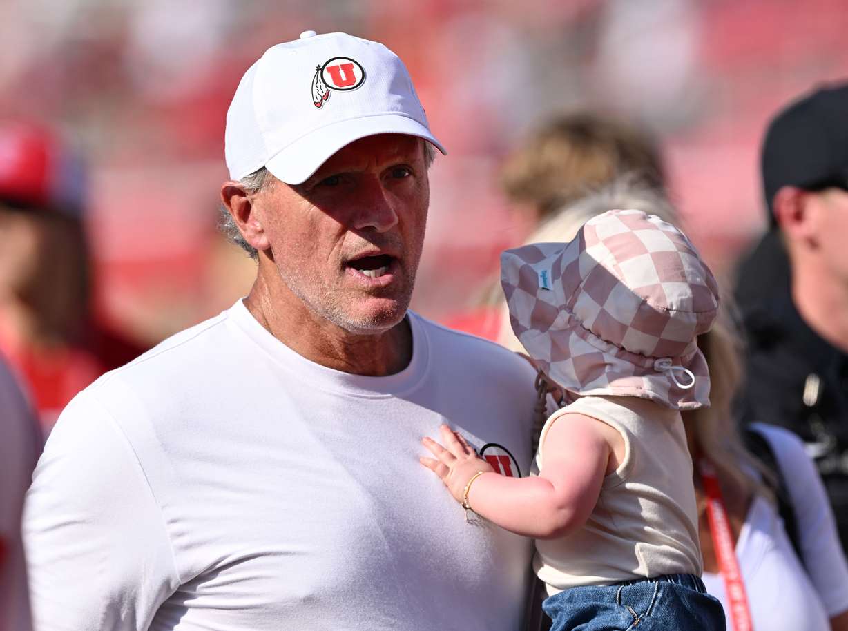 Utah Utes head coach Kyle Whittingham carries his granddaughter as he leaves the field after Utah defeated Baylor at Rice-Eccles Stadium in Salt Lake City on Saturday, Sept. 7, 2024. Utah won 23-12.