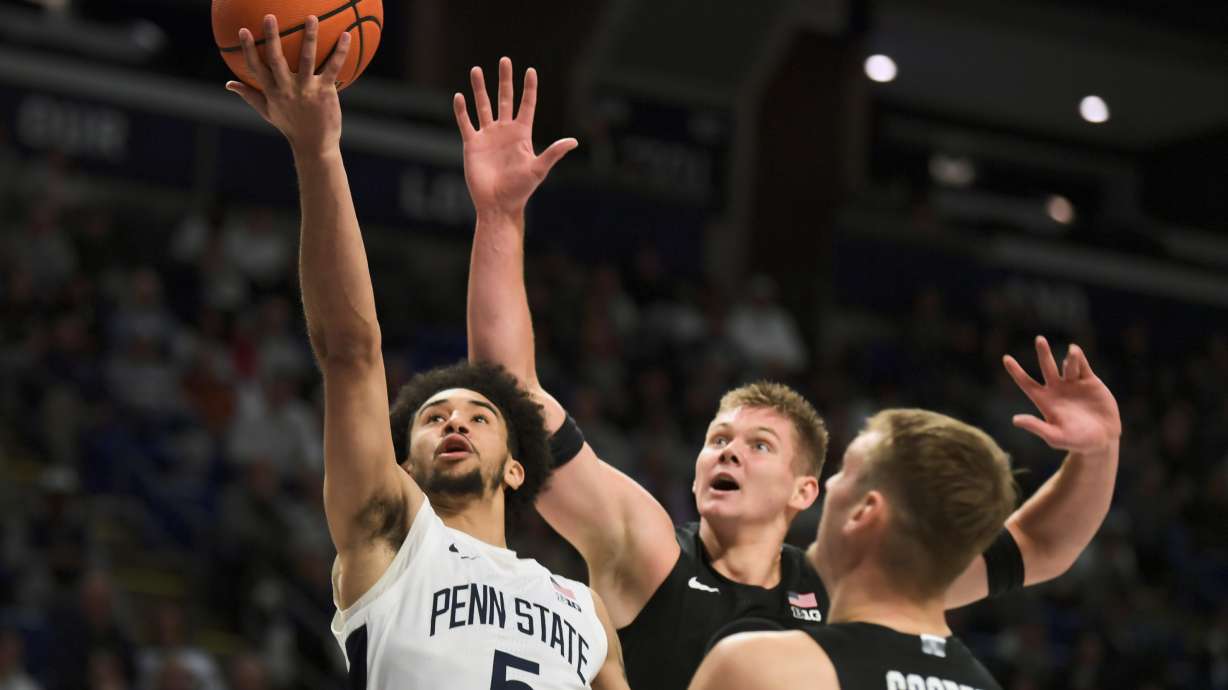 Michigan State's Jaxon Kohler, center, and Carson Cooper (15) attempt to block a shot by Penn State's Freddie Dilione V (5) during the first half of an NCAA college basketball game Saturday, Dec. 13, 2025, in State College, Pa.