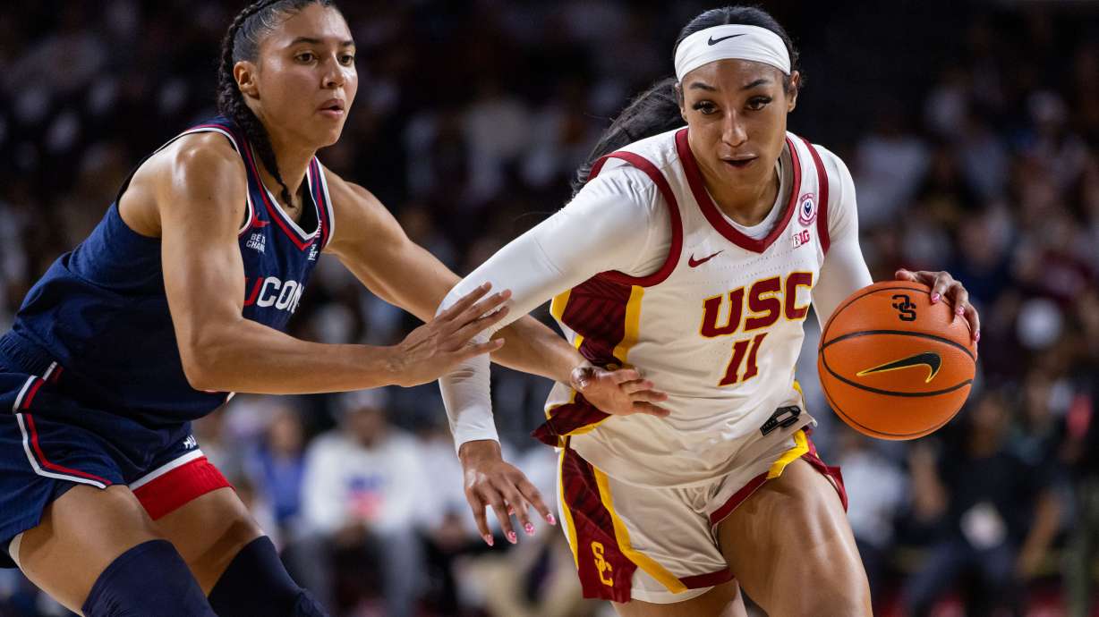 Southern California guard Kennedy Smith (11) drives the ball against UConn guard Azzi Fudd (35) during the first half of an NCAA college basketball game Saturday, Dec. 13, 2025, in Los Angeles.