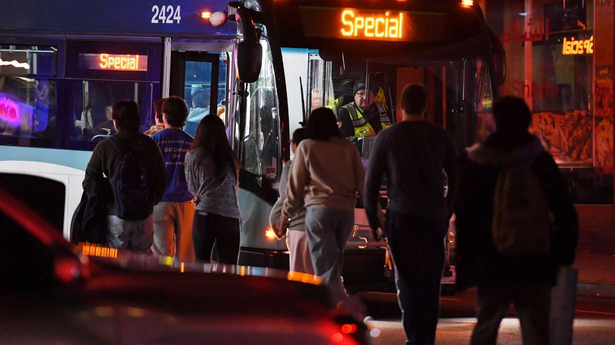 People board a bus in a neighborhood near Brown University, Saturday, in Providence, R.I., during the investigation of a shooting. Authorities are searching for the shooter who killed at least two people and wounded nine others during final exams on the Ivy League campus.