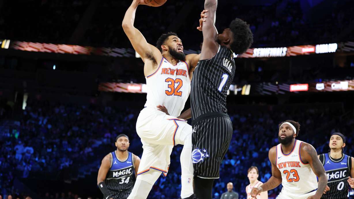 New York Knocks center Karl-Anthony Towns (32) and Orlando Magic forward Jonathan Isaac (1) tangle near the net during the first half of an NBA Cup semifinals basketball game, Saturday, Dec. 13, 2025, in Las Vegas.