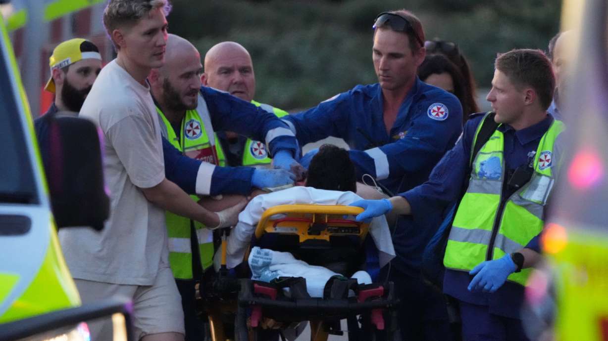 Emergency workers transport a person on a stretcher after a reported shooting at Bondi Beach, in Sydney, Sunday.