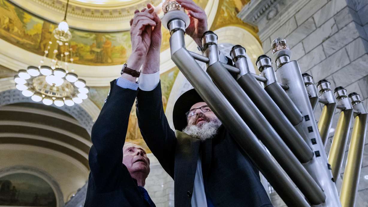 Former U.S. Ambassador John Price and Rabbi Benny Zippel light the first candle of a menorah at the state Capitol Dec. 18, 2022. A Utah celebration of Hanukkah will proceed Sunday night, despite a mass shooting at a Sydney Hanukkah celebration.