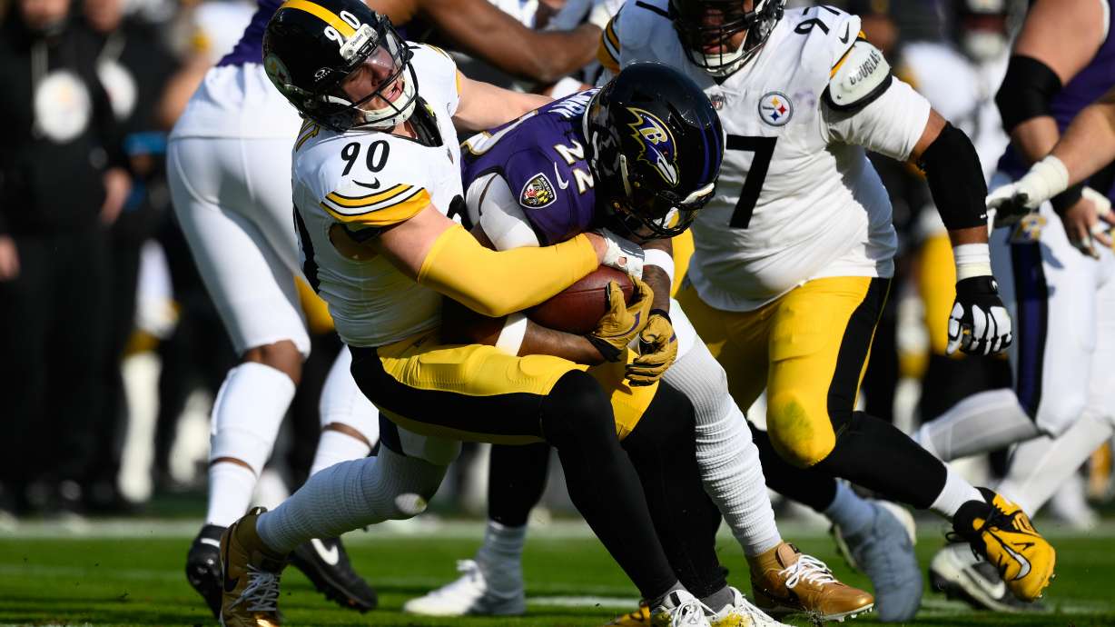 Pittsburgh Steelers linebacker T.J. Watt (90) tackles Baltimore Ravens running back Derrick Henry (22) during the first half of an NFL football game, Sunday, Dec. 7, 2025, in Baltimore.