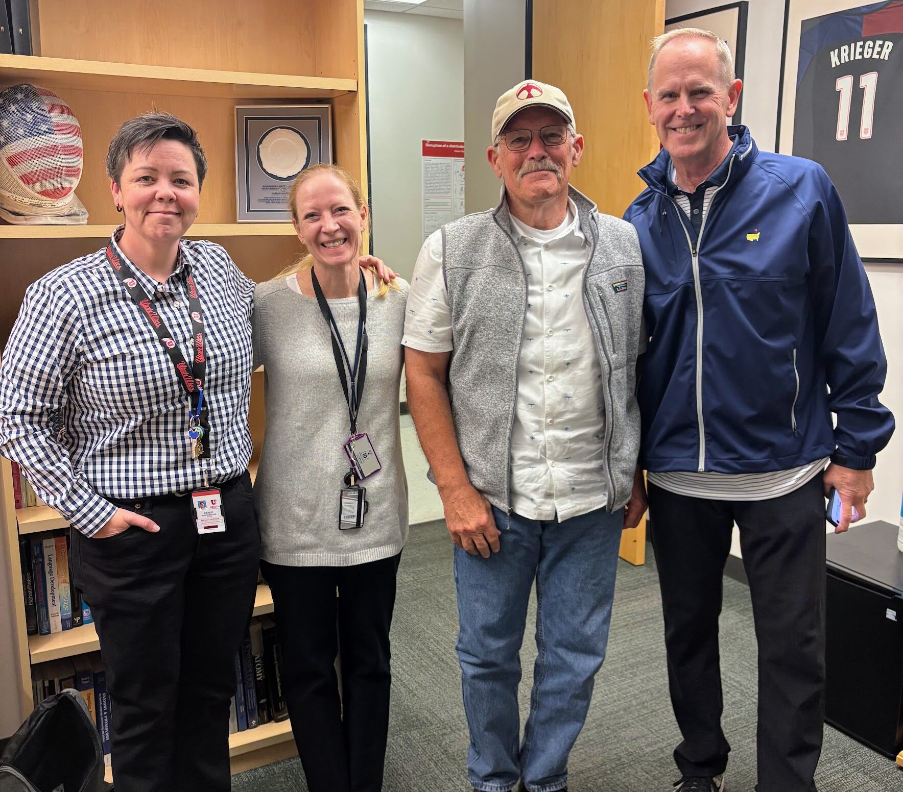 Neuropsychologists Carrie Esopenko and Elisabeth Wilde, co-directors of the Traumatic Brain Injury and Concussion Center at the University of Utah, pose with former football players Larry Carr and Tom Holmoe at the neuroscience building. Recently retired as BYU athletic director, Holmoe has agreed to participate in a study on infrared light therapy called photobiomodulation and publicize his results.