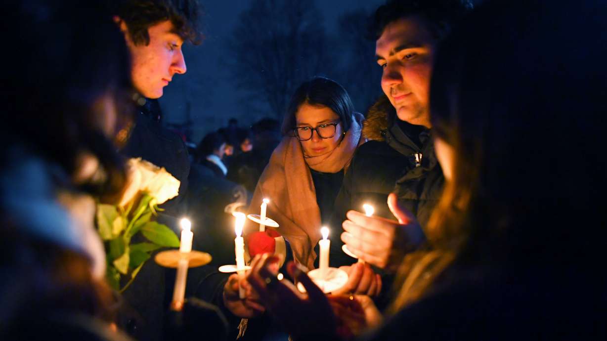 People hold candles during a vigil, Sunday, in Providence, R.I., for those injured or killed during the Saturday shooting on Brown University campus.