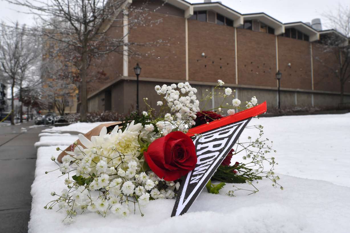 A bouquet of flowers rests on snow, Sunday, on the campus of Brown University, not far from where a shooting took place, in Providence, R.I.